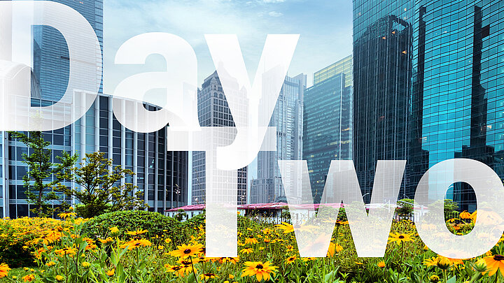 Abstract graphic of large "Day Two" text and modern city in the background.