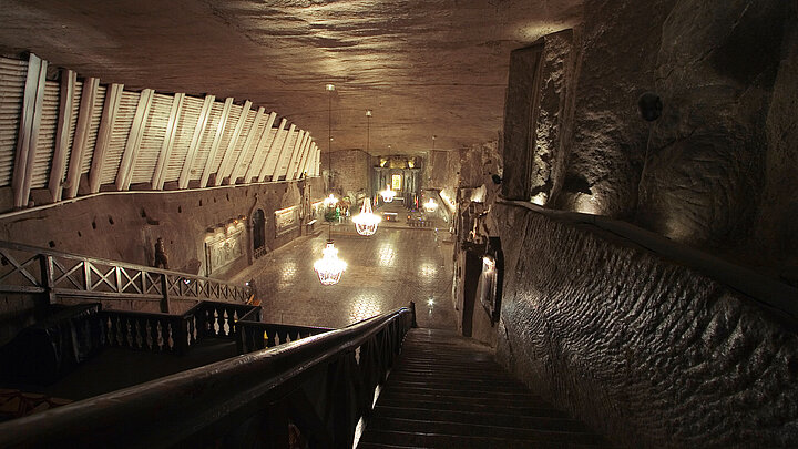 Underground salt mine chamber. Large, carved candelabra illuminate the scenery.